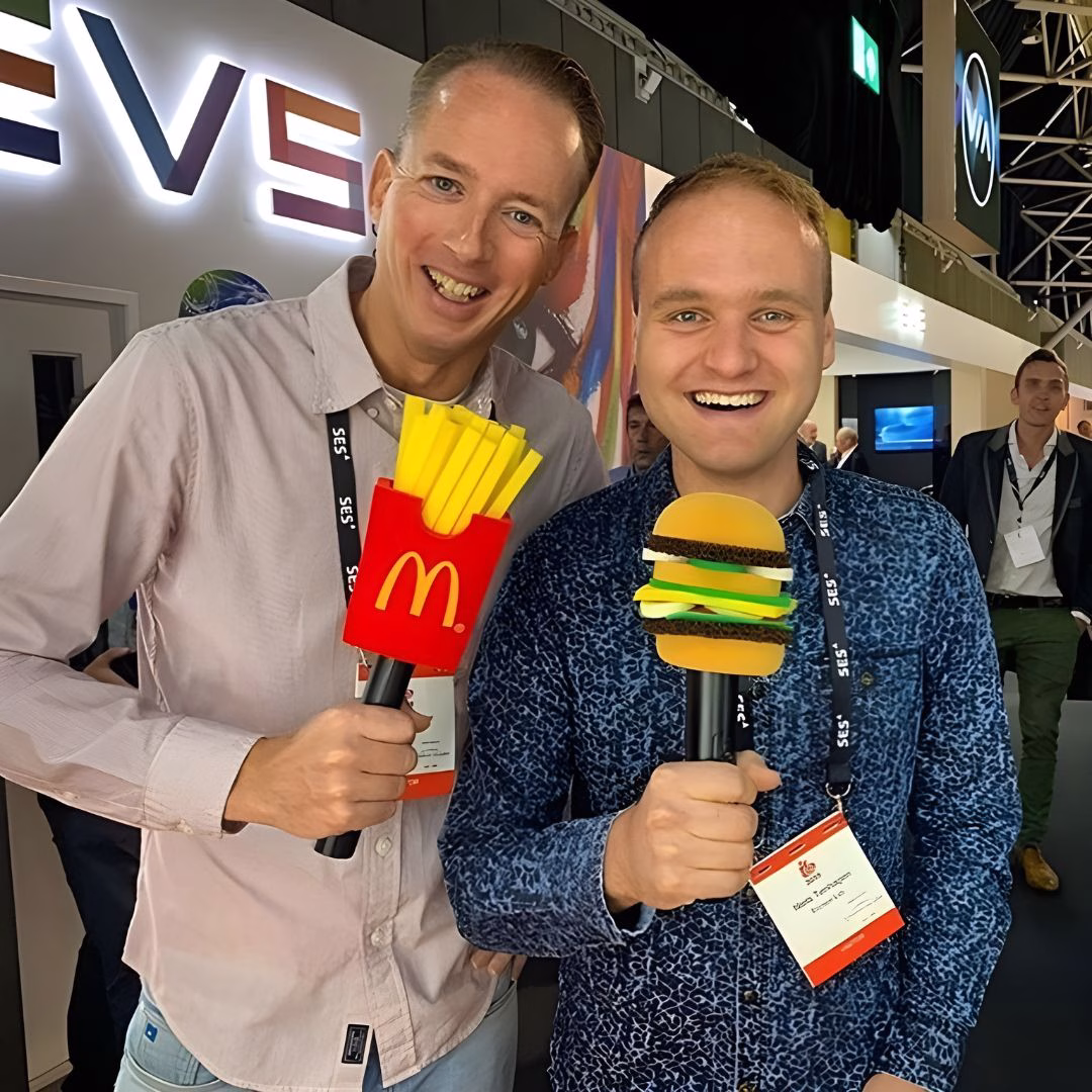two men holding custom branded microphone windshields